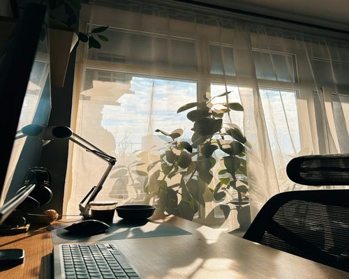 organized work desk with water and natural light