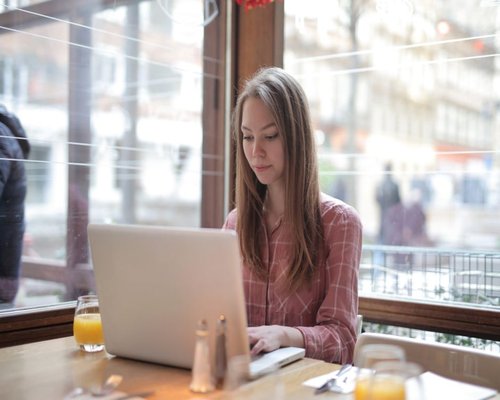 person working on a laptop beside a bright window in Spain